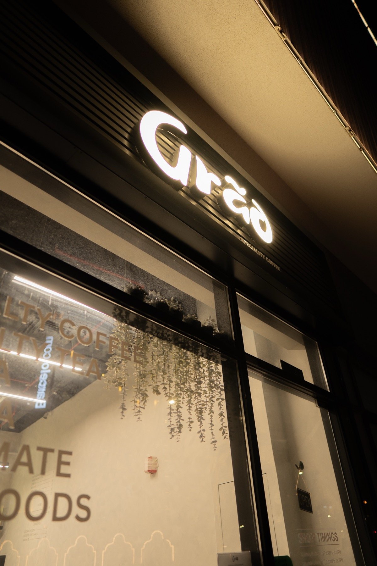Illuminated Grāo storefront sign at night